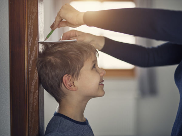 Mother measuring son's height